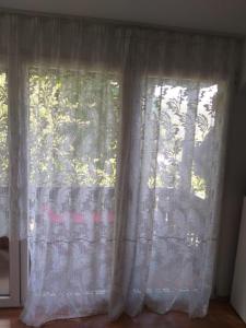 a window with white curtains in a room at Vila Ana Lăcrămioara Concept in Căciulata