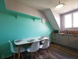 een keuken met een tafel en stoelen in een kamer bij Gites de l'isle - Séjours Pro - Wifi - Netflix - Plein centre-ville in Château-Thierry