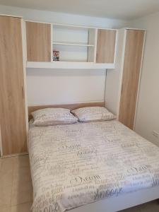 a small bed with two pillows in a bedroom at Apartmani Adam in Primošten