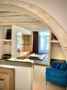 ein Wohnzimmer mit einem Bett und einem blauen Sofa in der Unterkunft Isabella di Castiglia Apartments in Syrakus