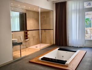 敘拉古的住宿－Isabella di Castiglia Apartments，带浴缸和玻璃淋浴间的浴室。
