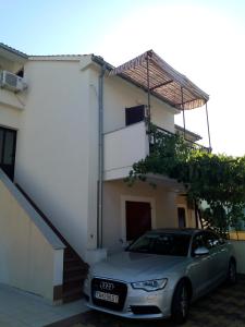 a car parked in front of a house at Vodice Mladen apartman za familiju in Vodice