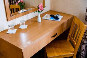 a wooden desk with a vase of flowers on it at Argo in Lviv