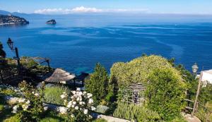 a view of the ocean from a hill with flowers at Paradiso Di Manù in Noli