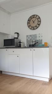 a white counter with a clock on a wall at Bel appartement F2 centre ville in Le Havre