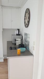 a kitchen with a counter with a clock on the wall at Bel appartement F2 centre ville in Le Havre