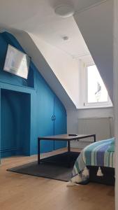 Pokój ze stołem i niebieską ścianą w obiekcie Bel appartement F2 centre ville w Hawrze