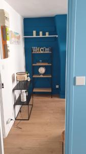 a room with a blue wall and shelves at Bel appartement F2 centre ville in Le Havre