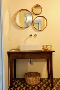 a bathroom with a sink and two mirrors on the wall at DimorAruci - Ospitalità Siciliana in Modica