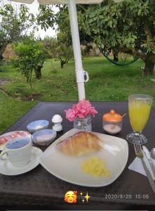 a table with a plate of food and a drink at Tababela Airport B&B in Tababela