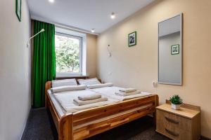ein Schlafzimmer mit einem großen Bett mit einem grünen Vorhang in der Unterkunft The CUBE rooms in Lwiw