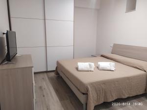 a bedroom with a bed with two white towels on it at Manolo Case Vacanza in Monopoli +76 photos