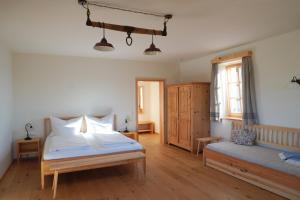een slaapkamer met een bed, een bank en een raam bij Bauernhof Gschmeidler in Sankt Johann im Saggautal