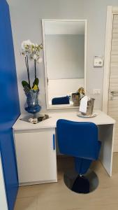 a desk with a blue chair and a mirror at Terrazze Naos in San Leone