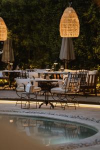 un grupo de sillas y mesas junto a una piscina en The Bold Type Hotel, a Member of Design Hotels, en Patra