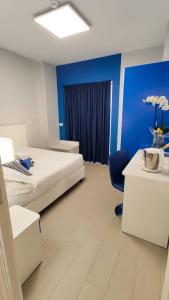 a room with two beds and a blue wall at Terrazze Naos in San Leone