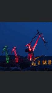 three cranes are lit up in red and green at Litore in Pula