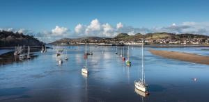 a group of boats are sitting in the water at The Castle Hotel, Conwy, North Wales in Conwy