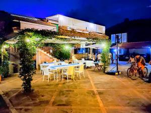 a restaurant with white tables and chairs and lights at That's Amore Cilento Country House in Agnone