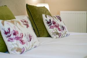 a bed with three pillows on top of it at Great Ashley Farm Bed and Breakfast & Shepherds Huts in Bradford on Avon