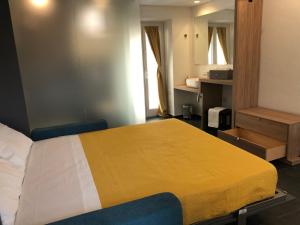 a bedroom with a large bed with a yellow blanket at Alley House in Cefalù