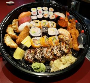 ein Teller mit Sushi und anderen Speisen auf einem Tisch in der Unterkunft Parkhotel Bergheim in Bergheim + 11 Fotos