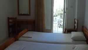 ルトラ・エディプソスにあるMouroukis Roomsのツインベッド2台 窓付きの部屋