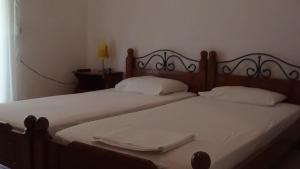 ルトラ・エディプソスにあるMouroukis Roomsのベッド2台(白いシーツ、白いタオル付)