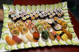 ein Teller mit Sushi und Gemüse auf einem Tisch in der Unterkunft Parkhotel Bergheim in Bergheim
