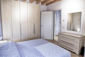 een slaapkamer met een bed, een dressoir en een spiegel bij Vicolo J. Da Ponte - Bassano Centro Storico in Bassano del Grappa