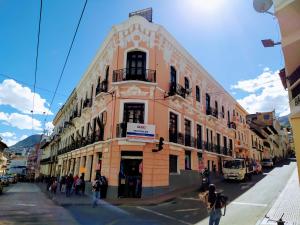 Un edificio in una strada con gente che cammina davanti di Hostal Latitud Ecuem a Quito