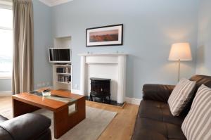 a living room with a couch and a fireplace at Upper Alta Apartment in Tighnabruaich