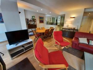 a living room with red chairs and a television at Altissim Apartments in Pas de la Casa