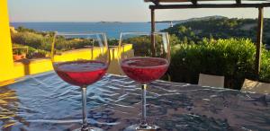 two glasses of red wine sitting on a table at VILLA CLAUDIO e LUNETTA in Villasimius