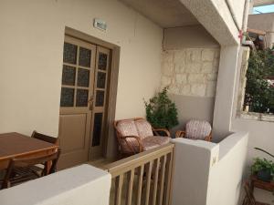 a balcony with chairs and a table and a door at Buganvilla Sea View apts in Agia Pelagia