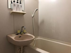 a white bathroom with a sink and a bath tub at 駅南うちやまビルさん in Fukuoka +11 photos