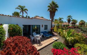 エル・パソにあるBungalow Villa Verde 1のヤシの木が植わるパティオ(テーブル、椅子付)