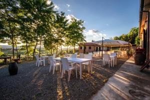 a group of white tables and chairs in a yard at Agriturismo Il Sambuco in Siena