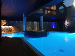 a large swimming pool in a building at night at May Cottage B&B in Bowness-on-Windermere