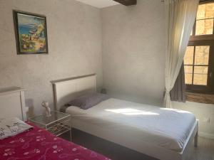 a small bedroom with a bed and a window at La Maison De Chloe in Senouillac