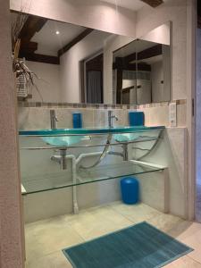 a bathroom with two glass sinks and a mirror at La Maison De Chloe in Senouillac