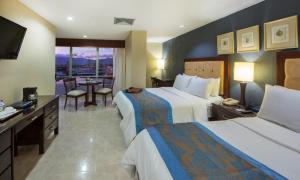 a hotel room with two beds and a television at Hodelpa Centro Plaza in Santiago de los Caballeros