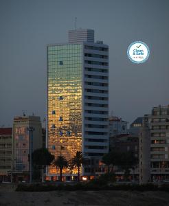 フィゲイラ・ダ・フォズにあるスウィート アトランティック ホテル & スパの時計付きの高層ビル