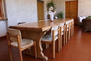 een lange houten tafel met stoelen en een vaas erop bij L'Oleandro in Loreto Aprutino