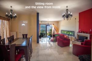 ein Esszimmer und ein Wohnzimmer mit einem Esstisch und Stühlen in der Unterkunft Helmata Villa with privecy in Argostoli