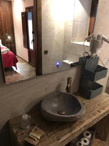 a bathroom with a stone sink and a mirror at Fonda Carrera in Labuerda