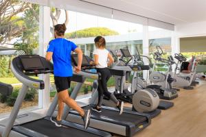 a man and a woman running on treadmills in a gym at Vale Do Lobo Resort in Vale do Lobo
