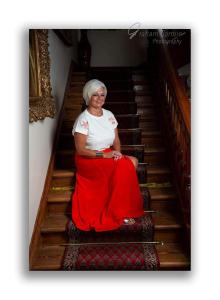 a woman sitting on a red bench in a room at St Michaels Guest House in Elgin