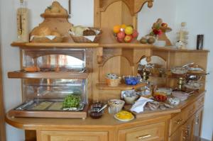 a kitchen with wooden cabinets with fruits and vegetables on it at Landhaus Montana in Gerlos