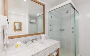 a bathroom with a shower, sink, and mirror at Posada Real Puerto Escondido in Puerto Escondido